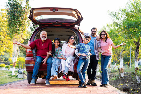 Indian family sitting in car dicky outdoors, enjoying laughter and bonding before a picnic
