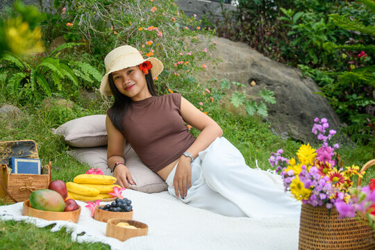 Girl lying on picnic blanket with hat