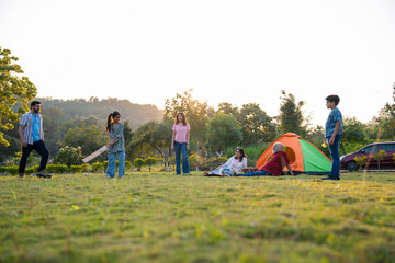 Indian family playing cricket while camping outdoors, sharing laughs and fun bonding moments
