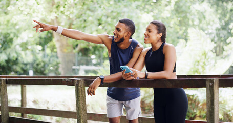 Pointing, phone and runner with couple outdoor for workout partner, running target and athlete tracking. Exercise app, route discussion and training landmark with man and woman on bridge for fitness