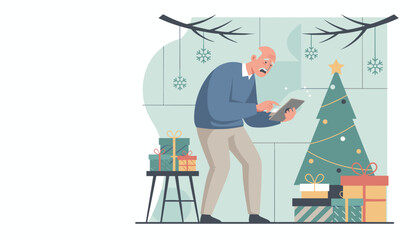 Senior man struggles with a tablet near a Christmas tree and gifts Holiday technology concept