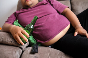 Unhealthy Lifestyle Choices with Fat Guy Lounging on the Couch with Beer Bottle