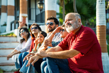 Indian family enjoying outdoor bonding time on steps during weekend relaxation
