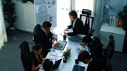 Top view of female leader looking financial statistic at business meeting. Professional marketing team looking and analyzing stock market investment graph and planning strategy. Teamwork. Directorate.