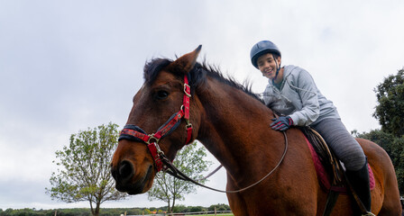 Happy girl riding horse enjoying equestrian activity