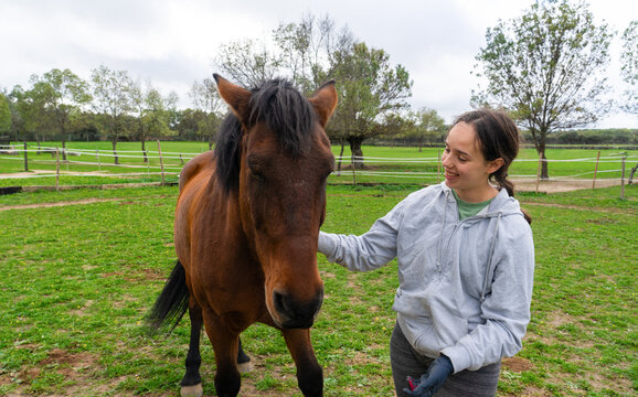 Woman petting horse feeling happy and relaxed - Powered by Adobe