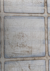 Surface of a weathered metal texture with scratches showing signs of wear and tear, a greyish tone creating an industrial look