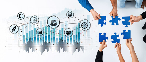 Diverse team members collaborate by connecting puzzle pieces against a backdrop of data visualization, emphasizing teamwork and strategic growth in business. Trope