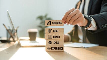 Stacked wooden blocks with motivational words such as future, skill, learning, and success on wooden background, human hand arranging blocks, soft sunlight, shallow depth field.