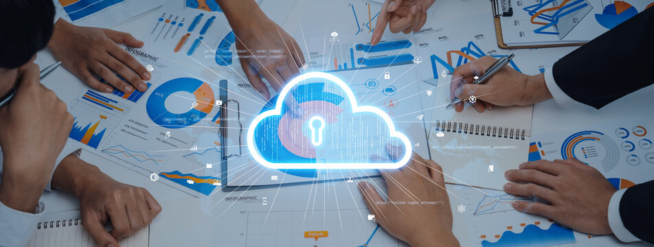 A diverse team engaged in a strategic meeting focused on cloud security, analyzing data charts, and graphs on a conference table in a modern workspace. Trope
