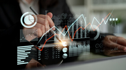 A business professional analyzes dynamic data trends using digital charts and graphs on a touchscreen, showcasing a modern approach to financial analysis and market research. Scalp