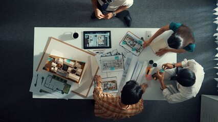 Top down aerial view of architect engineer team writing sticky notes and sticking note at house...