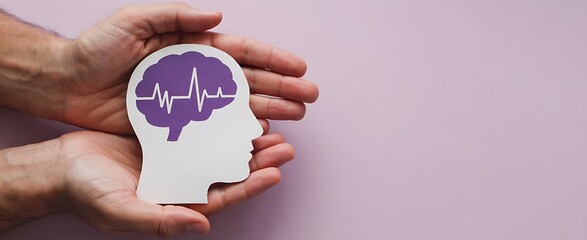 Hands gently cradling a paper cutout of a human head with a purple brain and heartbeat line inside symbolizing mental health awareness and care