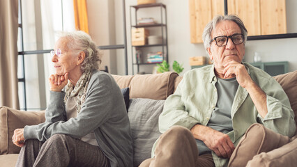 Mature couple sitting back to back not talking