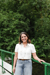 Woman poses on green bridge with calm expression