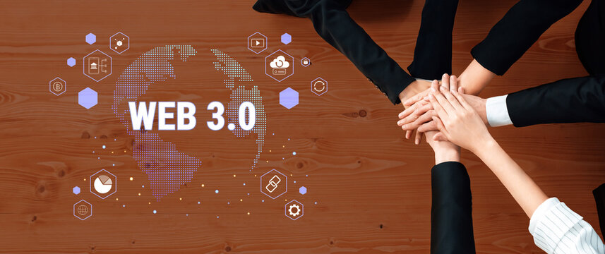 A diverse business team collaborates on Web 3.0 innovations, showcasing unity with hands stacked on a surface, surrounded by visual graphics representing global technology themes. Trope