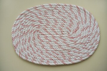 Round handmade doormat made from woven recycled fabric on a bright background. Creative handicrafts for household items.










 