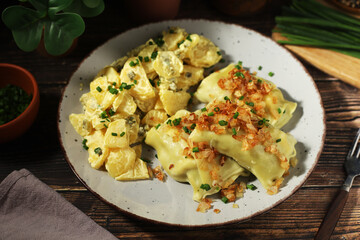 Traditional Swabian dish Maultaschen served with roasted onion and potato salad