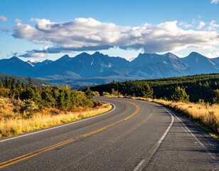 Fototapeta premium Winding Road Leading to Mountain Range Under Partly Cloudy Sky