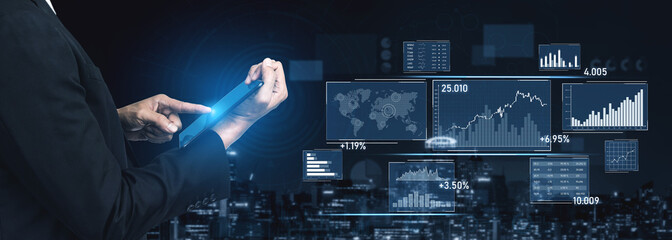 A business professional reviews dynamic financial data on a tablet, showcasing graphs, charts, and a world map against an urban backdrop, illustrating modern analytics. Scalp