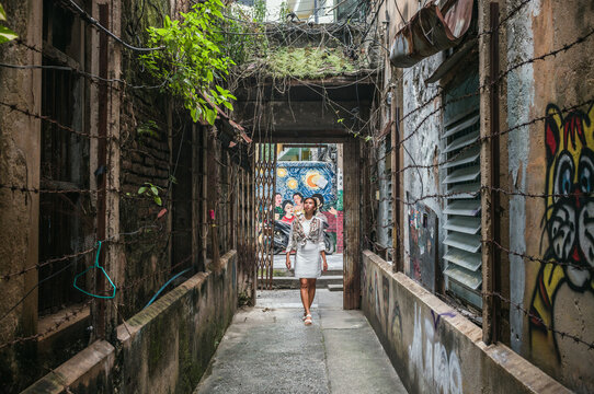 Young asian woman walking in a desolate alley, Bangkok, Thailand