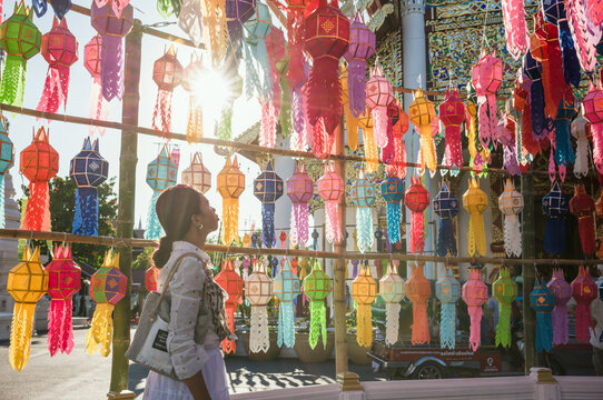 Asian woman looking at colorful paper lanterns, Chiang Mai, Thailand