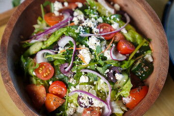 Close-Up of a Vibrant Greek or Mediterranean Salad with Feta Cheese, Olives, and Fresh Vegetables in a Wooden Bowl