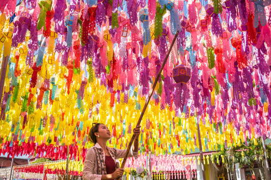 Asian woman hanging a paper lantern, Lamphun, Chiang Mai, Thailand