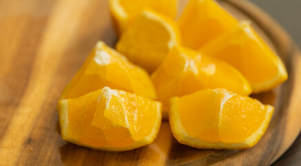 slicing fresh orange on wooden cutting board close-up