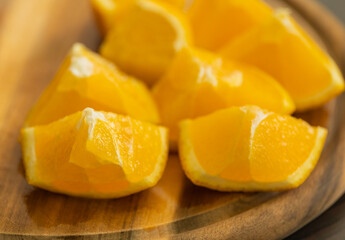 slicing fresh orange on wooden cutting board close-up