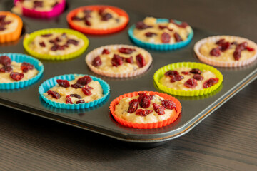 cranberry orange muffin cups filled with batter ready to bake