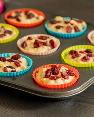 cranberry orange muffin cups filled with batter ready to bake