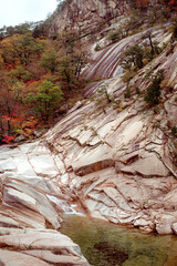 Seoraksan, South Korea, mountain landscape in autumn, a folded pyramid of stones against the background of a riverbed and bright colors of autumn.