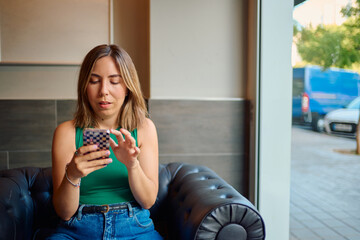 Woman relaxing on sofa using smartphone for social media