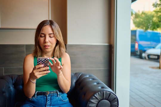 Woman relaxing on sofa using smartphone for social media