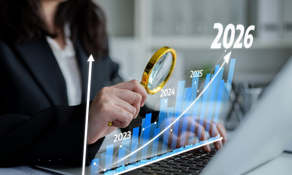 A business professional conducts an analysis of growth projections using a magnifying glass while working on a laptop, illustrating data trends and future planning. Tessel - Powered by Adobe