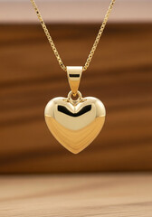 Gold heart-shaped pendant necklace on wooden background  
