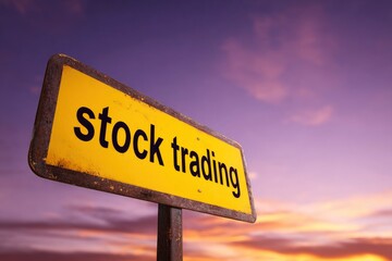 A yellow sign reads stock trading against a purpleorange sky The sign appears worn and is mounted on a rusty pole