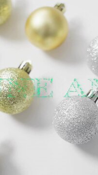 Animation of bonne annee text over christmas baubles on white background