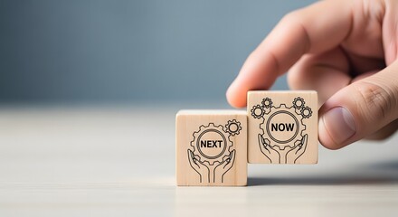 Wood blocks spelling next and now held by a hand representing choices