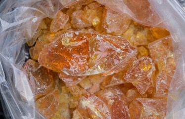 Close up of a piece of natural amber in a plastic bag.