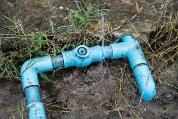 PVC water line of house plumbing system is leaking at the coupling connection. Building equipment object photo, close-up with selective focus.