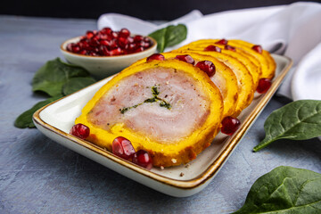festive serving of meat roulade with spinach, decorated with spinach leaves and pomegranate seeds