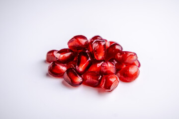A handful of pomegranate seeds on a white background