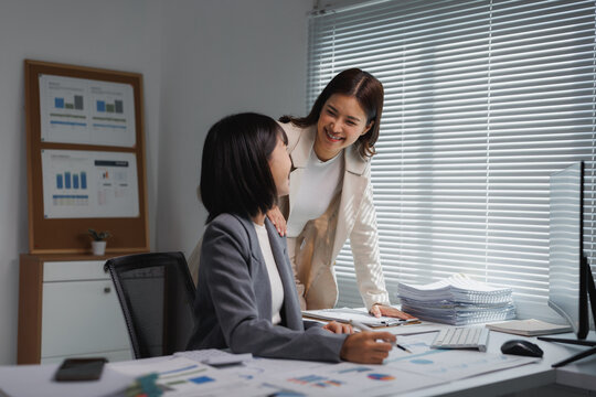 Businesswomen collaborating on project reviewing financial data