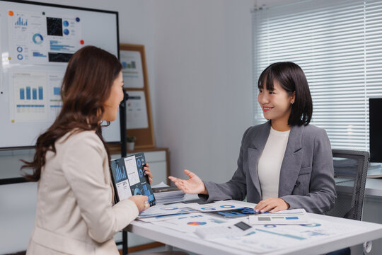 Businesswomen discussing marketing data analysis during office meeting