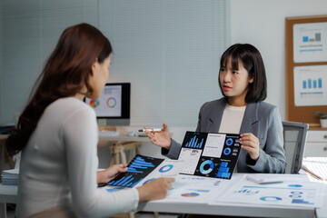 Businesswomen analyzing financial data presenting market report