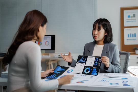 Businesswomen analyzing financial data presenting market report