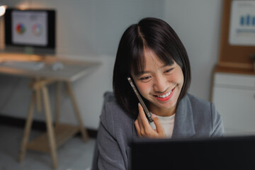 Asian businesswoman talking on cell phone working late