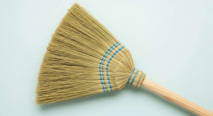Broom with natural straw bristles and wooden handle, showcasing craftsmanship and design, ideal for cleaning and home maintenance tasks, with copy space for text